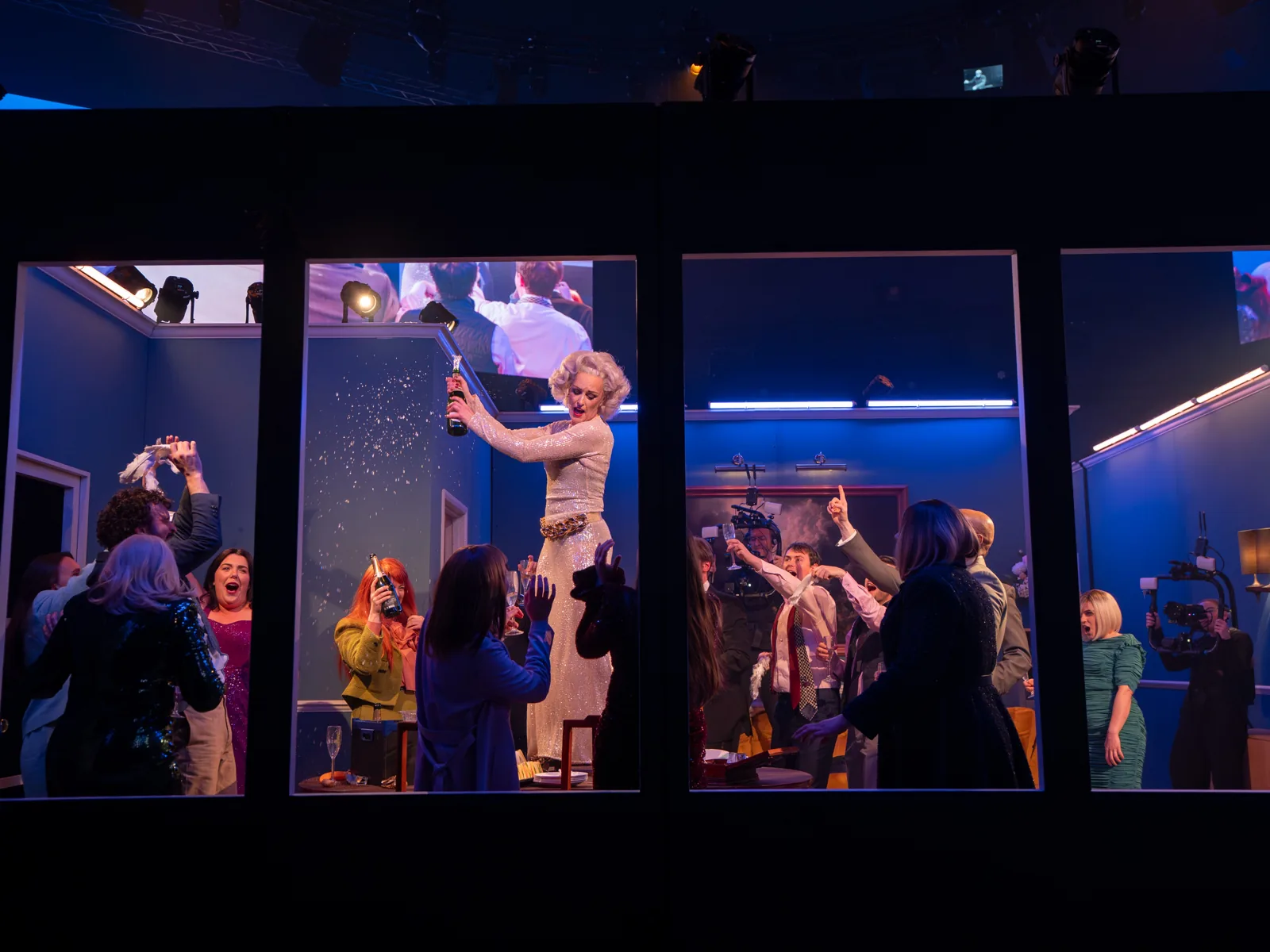 The cast seen through four lit windows of the set, Angel's Bone, London Coliseum
