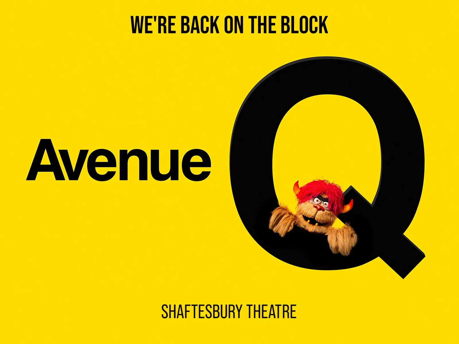 Red-haired puppet character inside large black Q in Avenue Q at the Shaftesbury Theatre