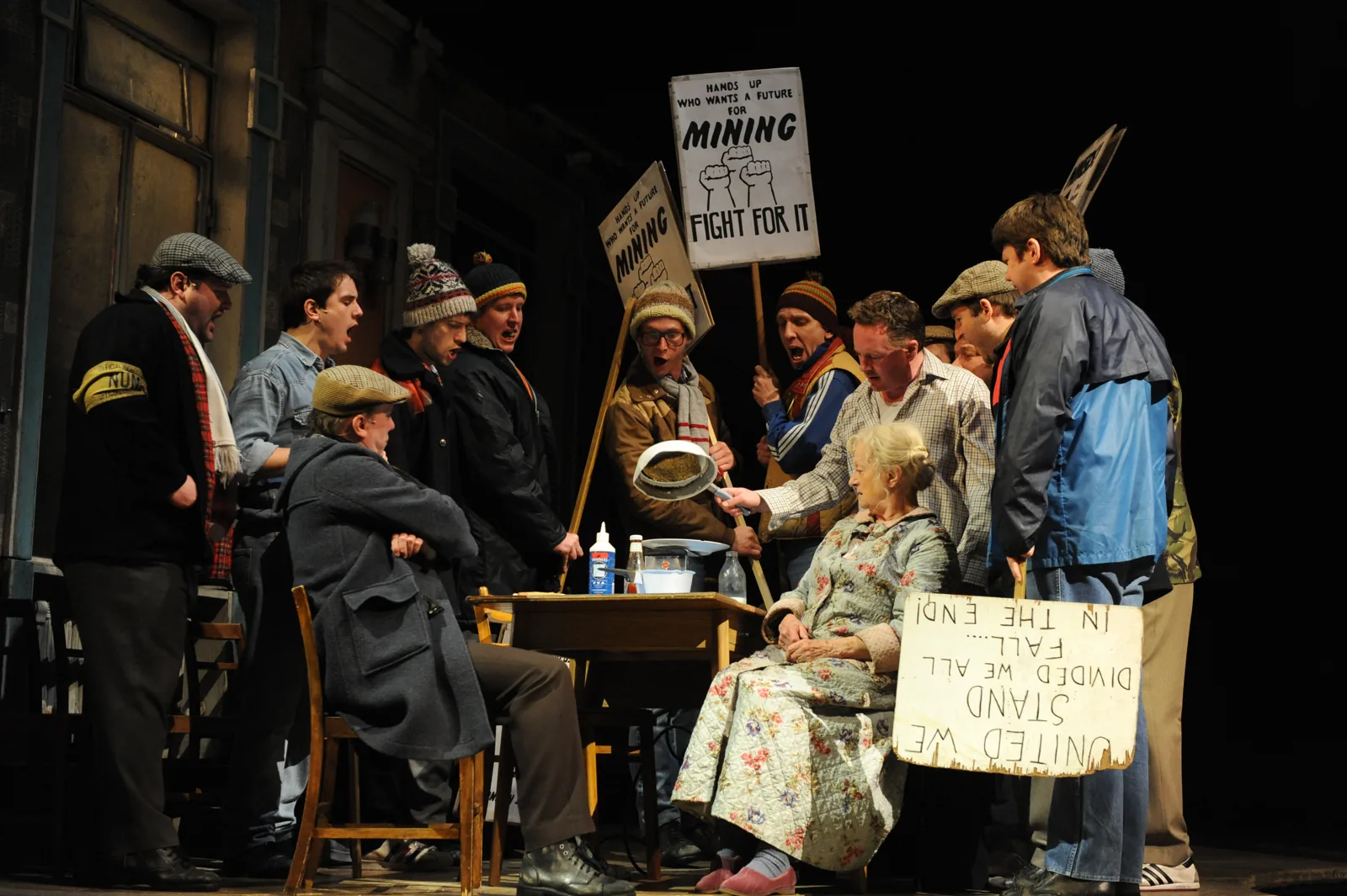 Striking miners with placards gather round Grandma and Dad in Billy Elliot the Musical