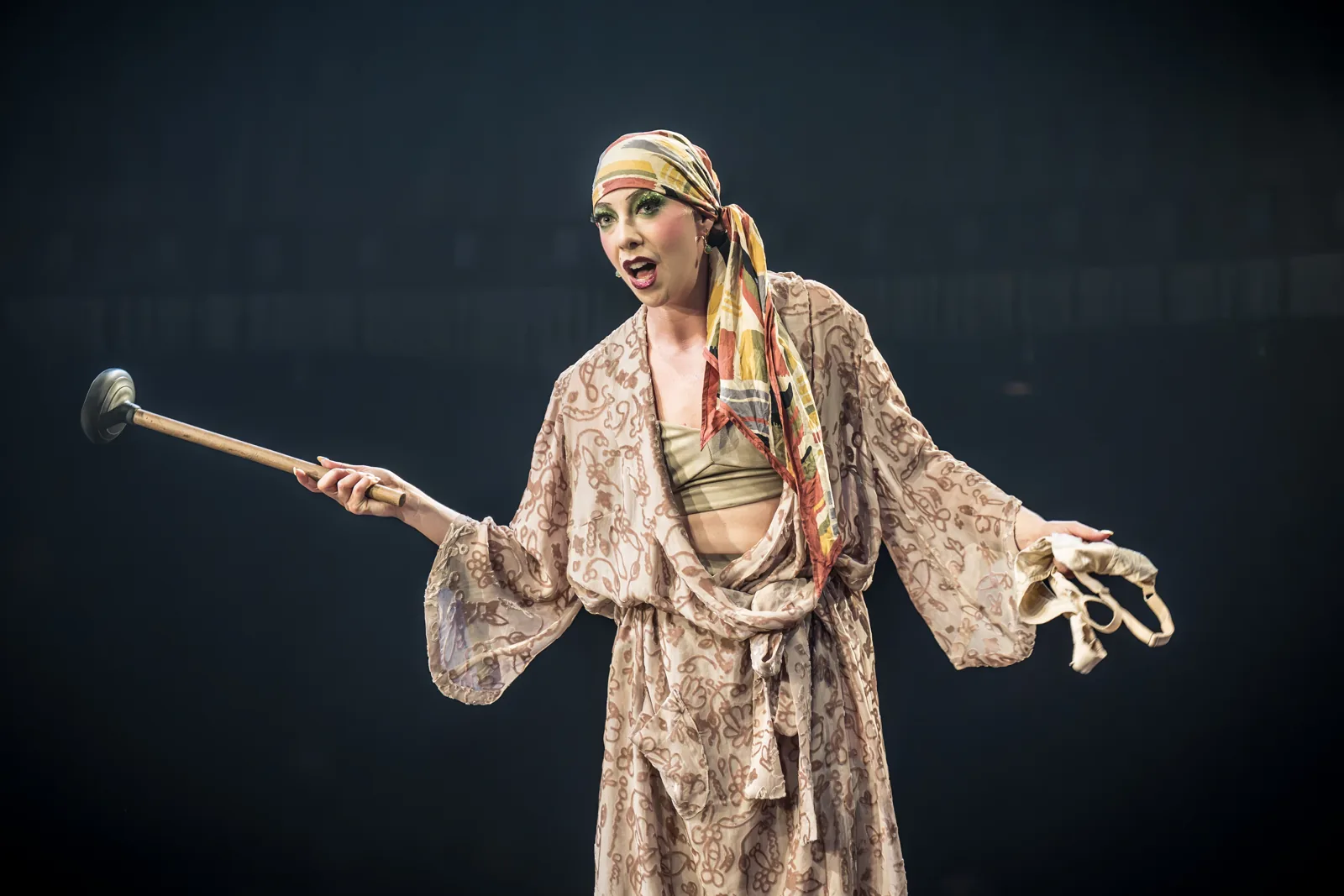 Fraulein Kost brandishes a sink plunger in Cabaret at the Kit Kat Club