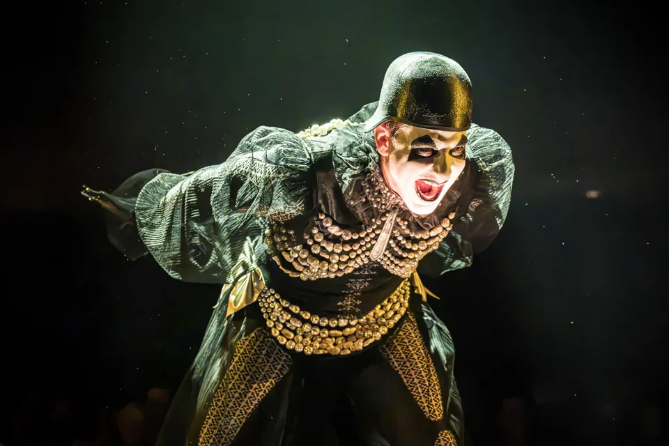 Skylar Astin as the Emcee in a gold mask and beads, Cabaret, Kit Kat Club