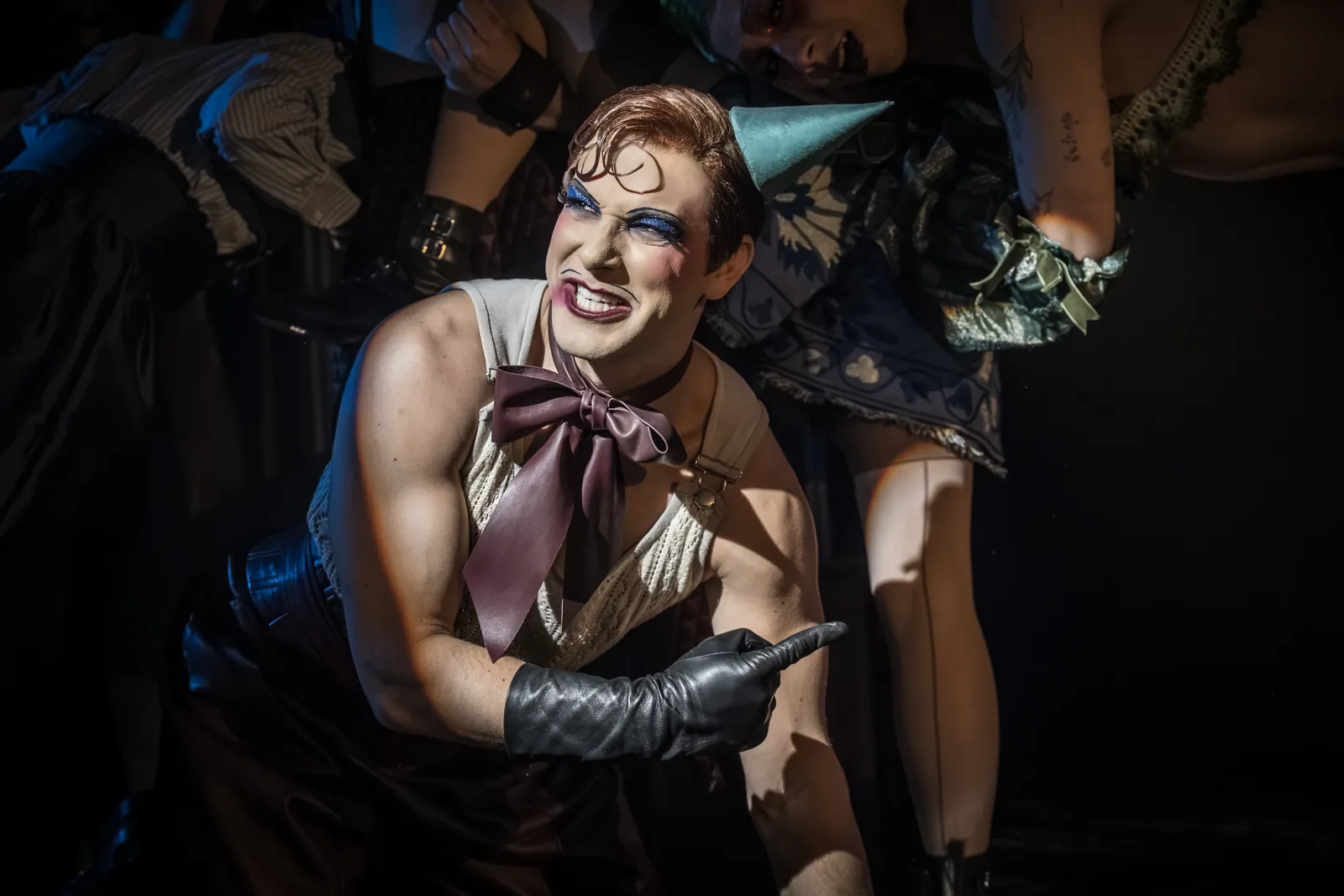 Skylar Astin as the Emcee in a party hat and bow, Cabaret, Kit Kat Club