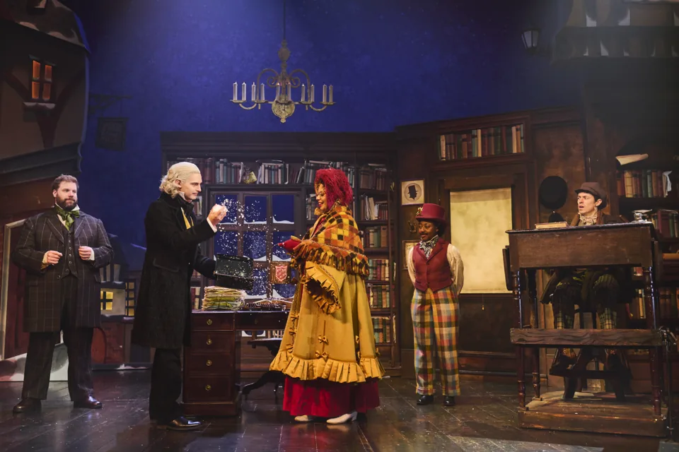 Five actors in Victorian costume in Scrooge's book-lined office, Christmas Carol Goes Wrong, Wyndham's Theatre