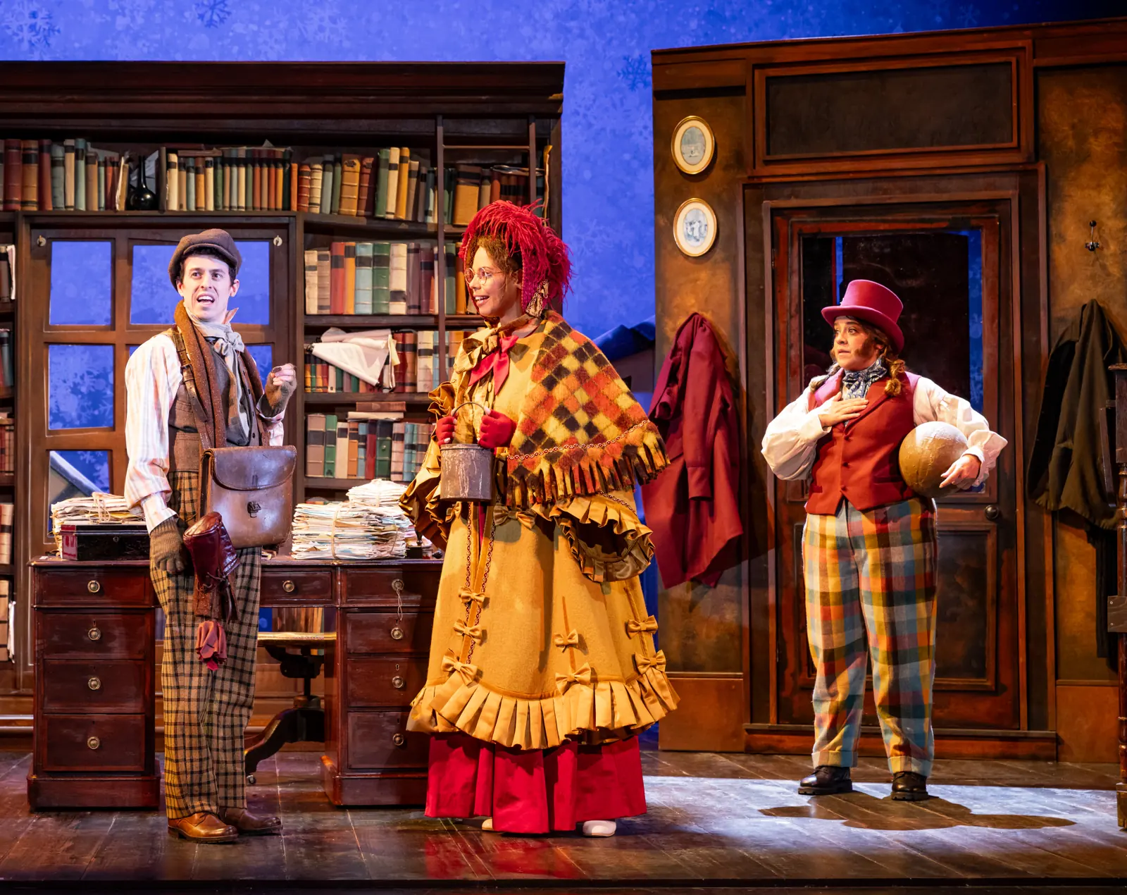 Three actors in Victorian costume in a book-lined office, Christmas Carol Goes Wrong, Wyndham's Theatre