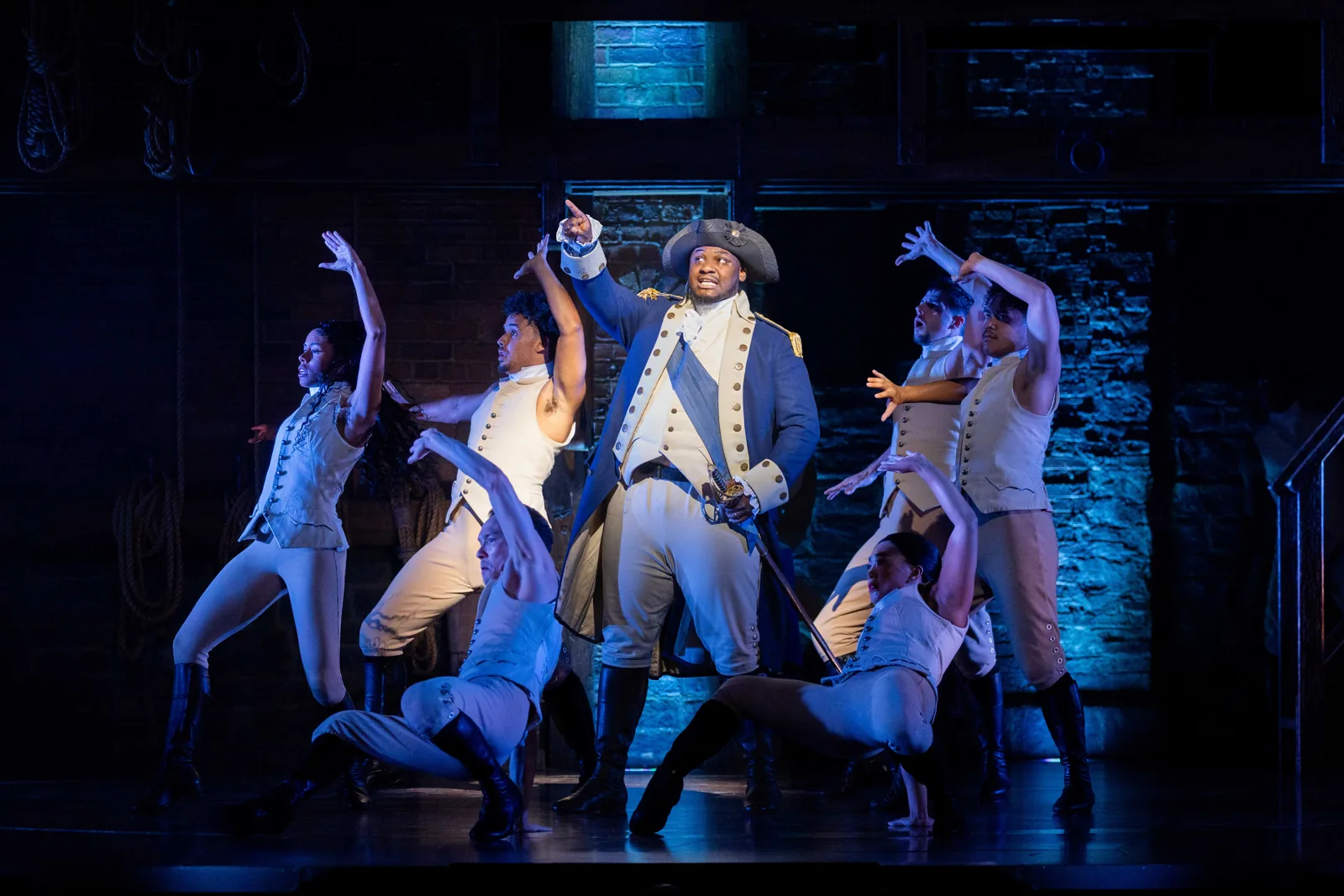 Akmed Junior Khemalai as George Washington with dancers around him in Hamilton, Victoria Palace Theatre
