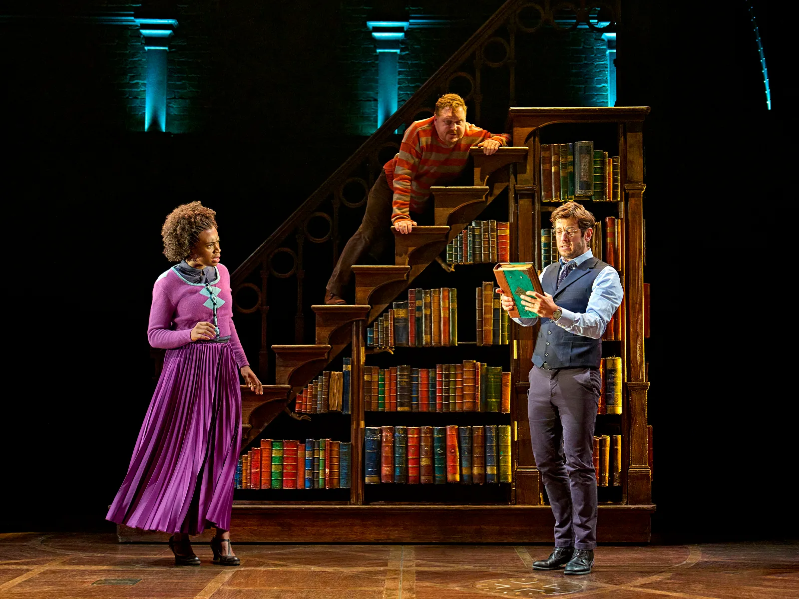 Three characters meet by a towering bookcase staircase, Cursed Child at the Palace Theatre
