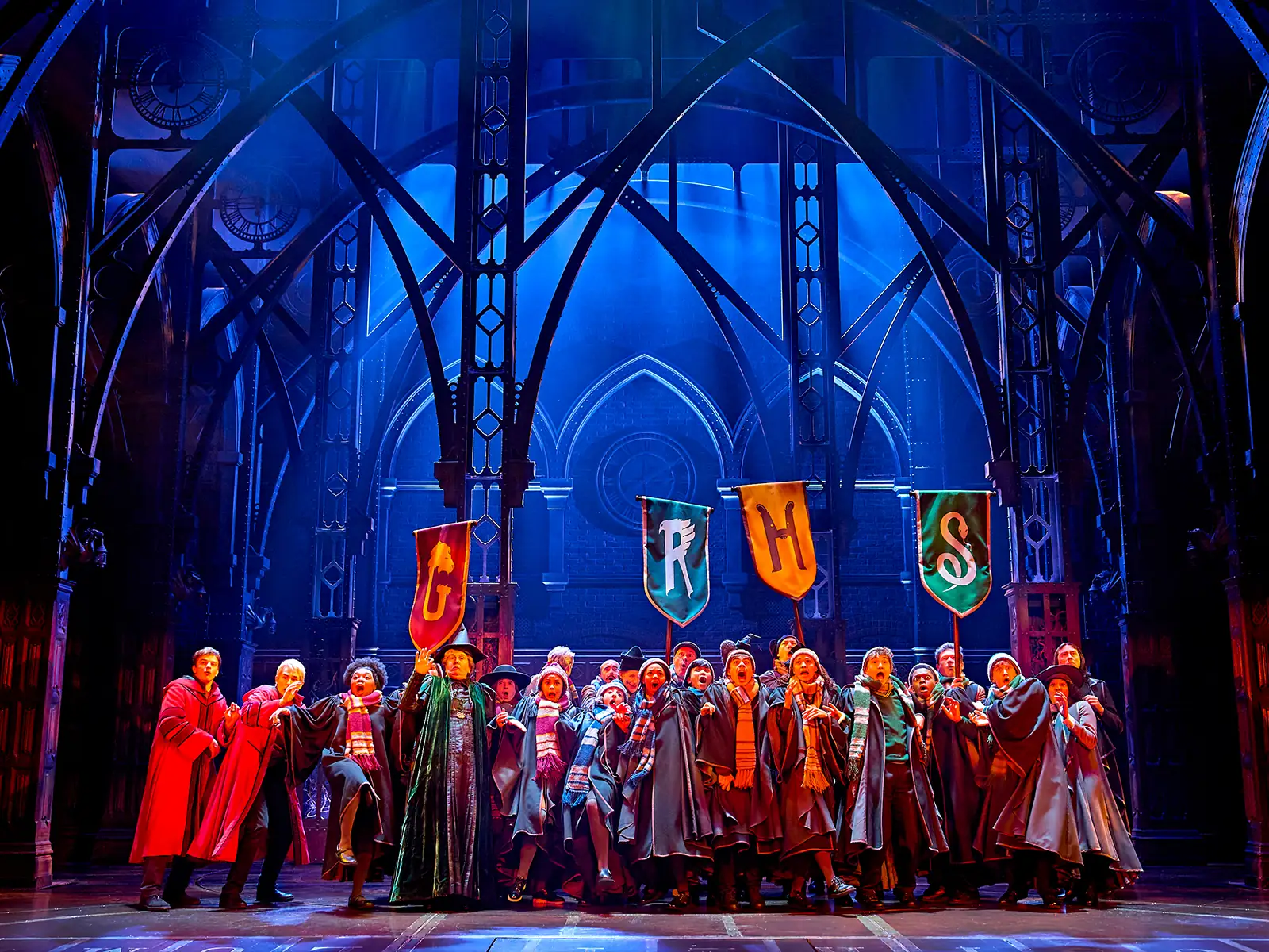 Robed students gather beneath the four house banners, Cursed Child at the Palace Theatre