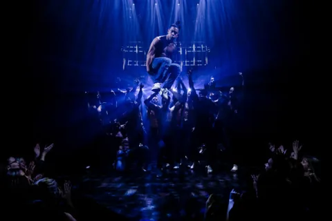 A dancer is lifted high above reaching hands, Magic Mike Live, Hippodrome Casino