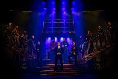 Dancers in dark suits line a double staircase, Magic Mike Live, Hippodrome Casino