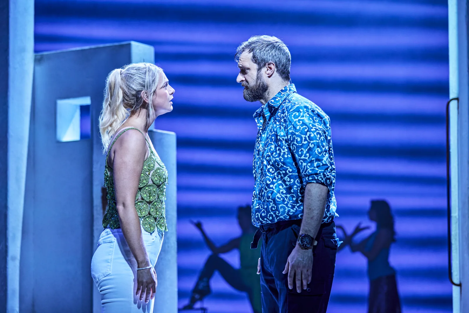 Sophie and Bill face each other against the striped set, Mamma Mia!, Novello Theatre