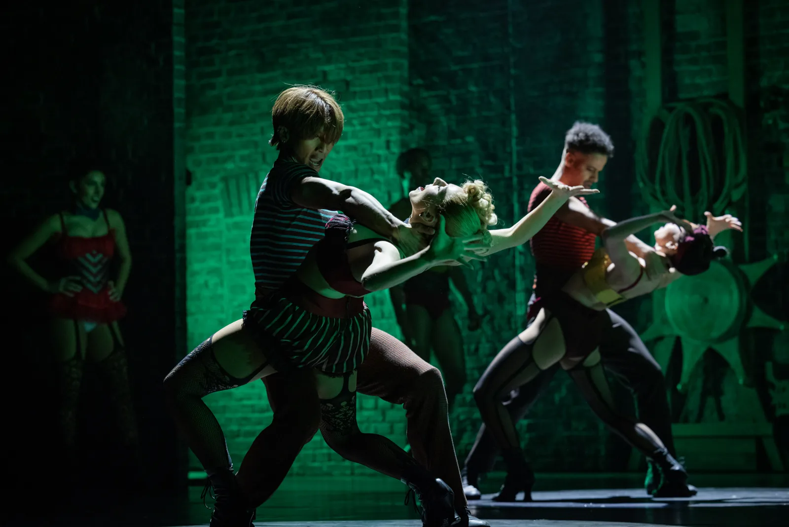 Two couples dance dramatic dips under green light in Moulin Rouge! The Musical, Piccadilly Theatre