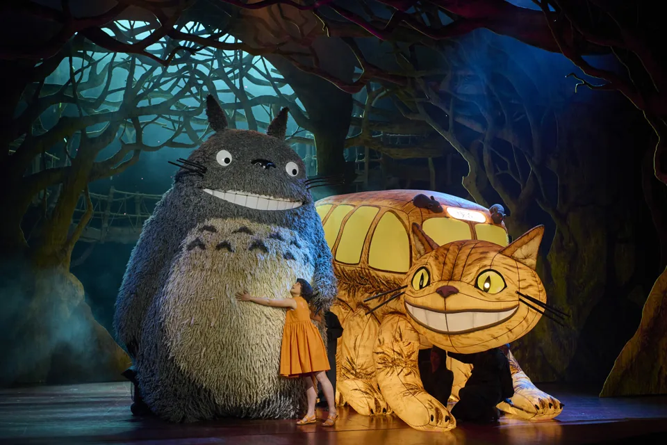 Satsuki hugs Totoro beside the grinning Catbus in My Neighbour Totoro, Gillian Lynne Theatre