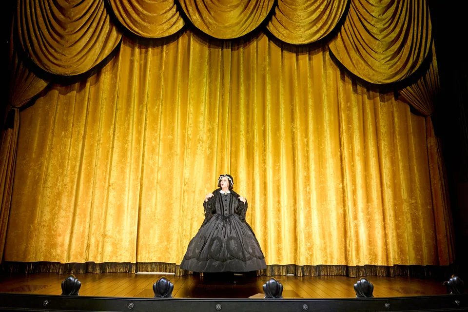 Mary Todd Lincoln alone before a gold curtain in Oh, Mary!, Trafalgar Theatre