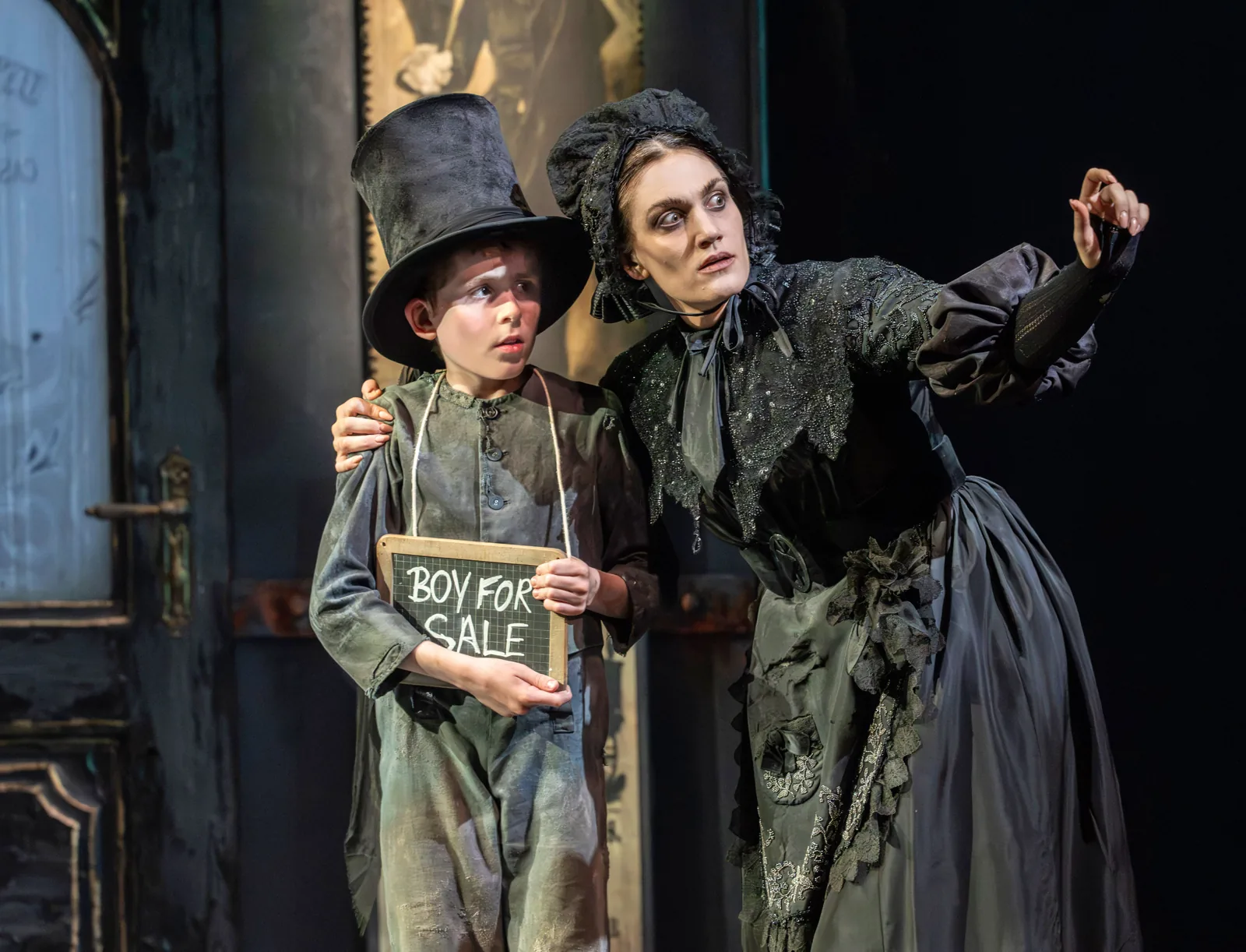 Oliver wears a Boy for Sale sign in Oliver! at the Gielgud Theatre