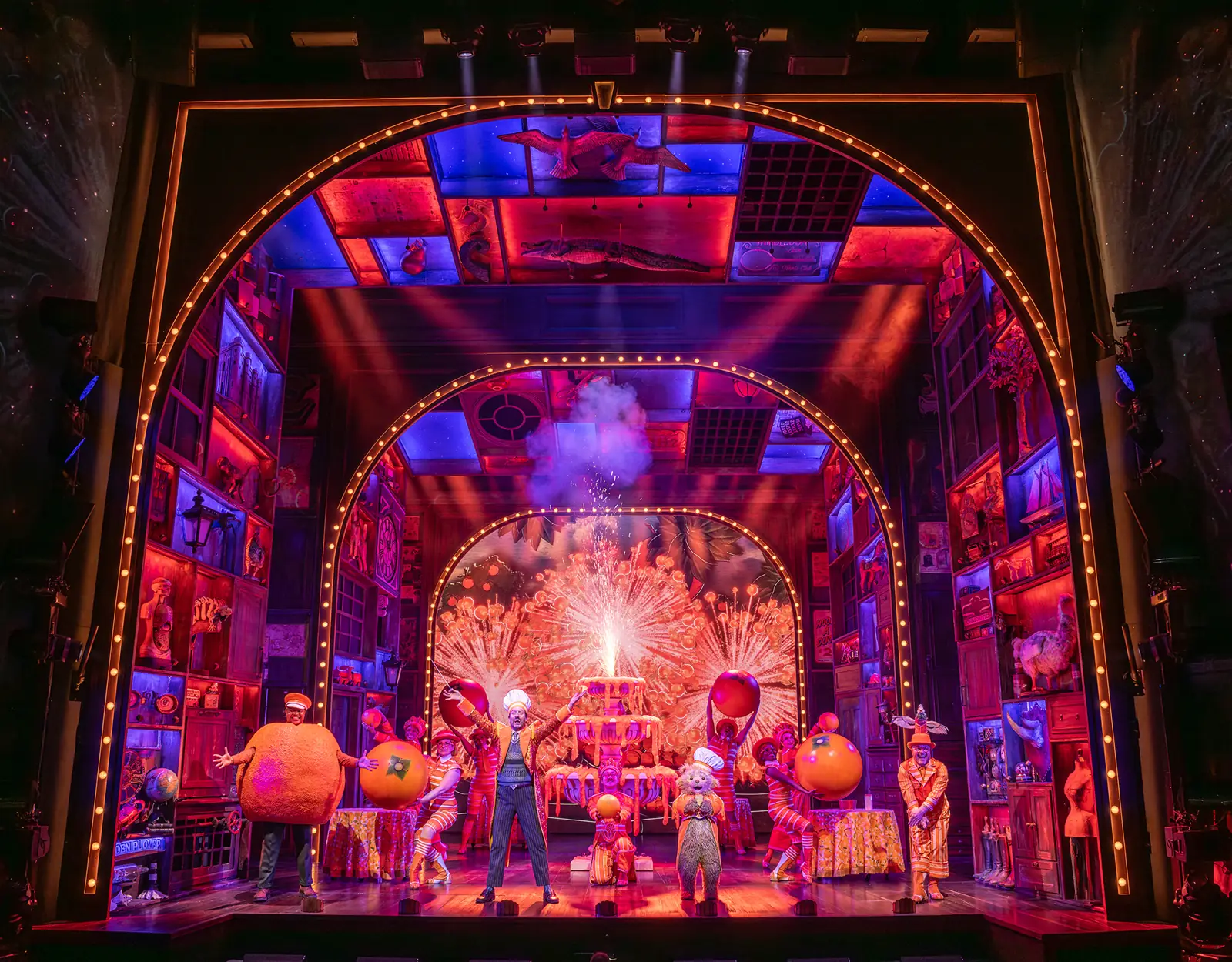 Giant oranges and sparks fill an arched stage in Paddington The Musical, Savoy Theatre