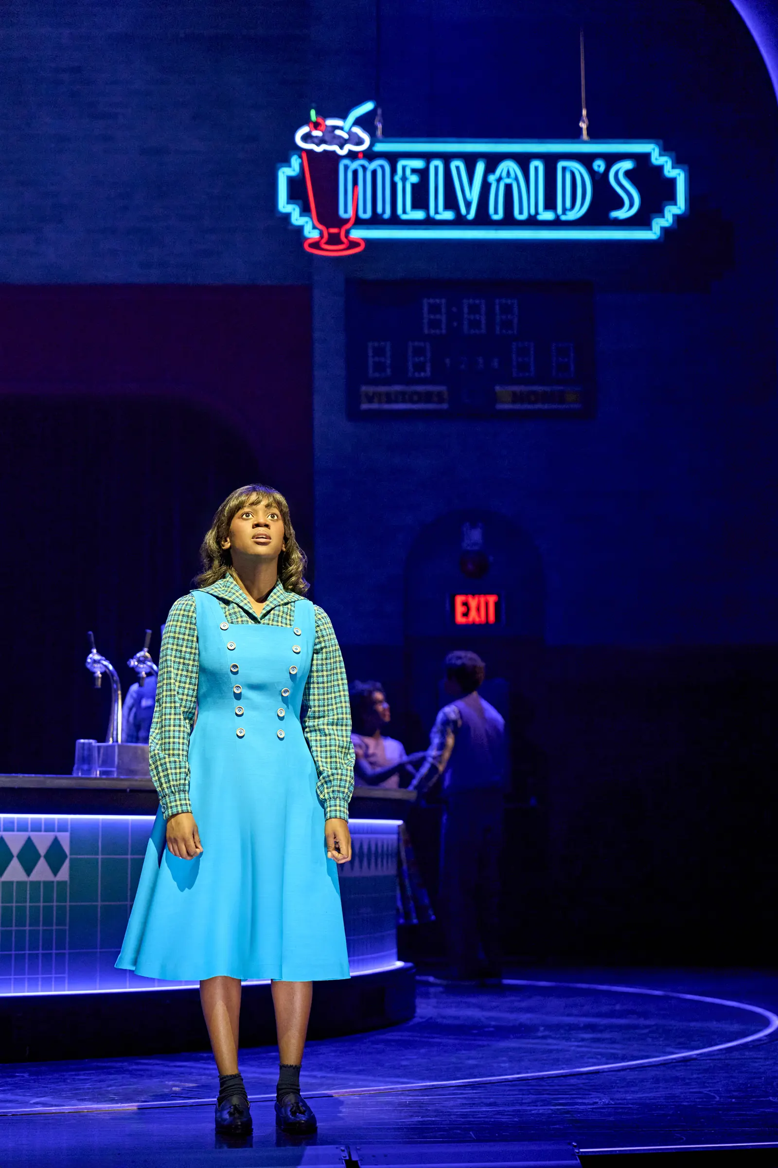 A woman in blue beneath the Melvald's neon sign: Stranger Things, Phoenix Theatre