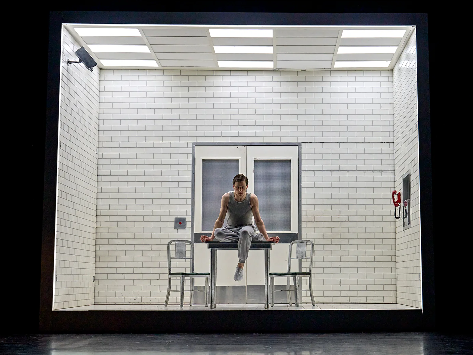 A young man sits on a table in a white lab: Stranger Things, Phoenix Theatre