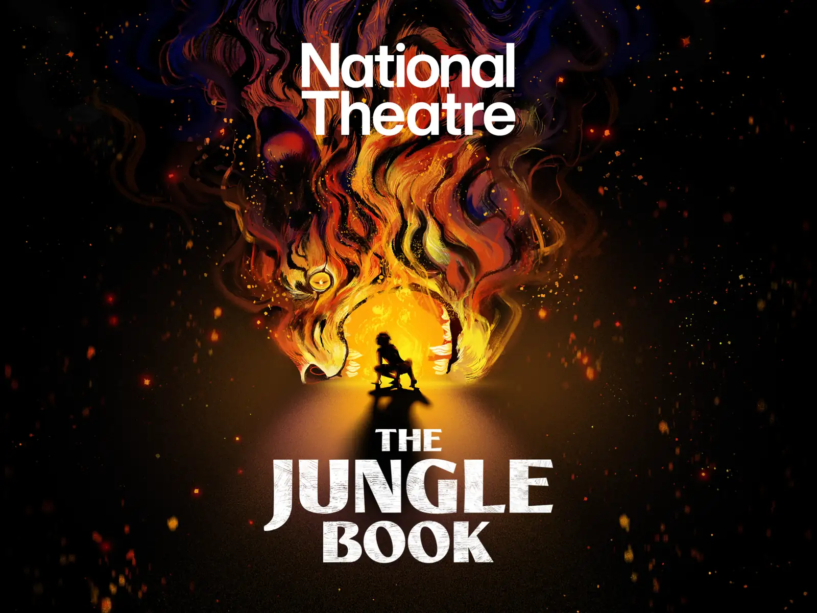 Silhouetted figure against flames and glowing light in The Jungle Book at the Olivier Theatre