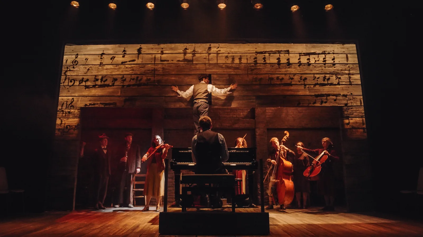 A conductor spreads his arms before the players in The Pianist, Park Theatre