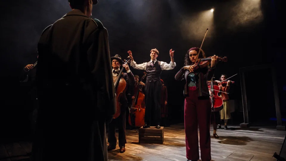 A violinist and string players perform in The Pianist, Park Theatre
