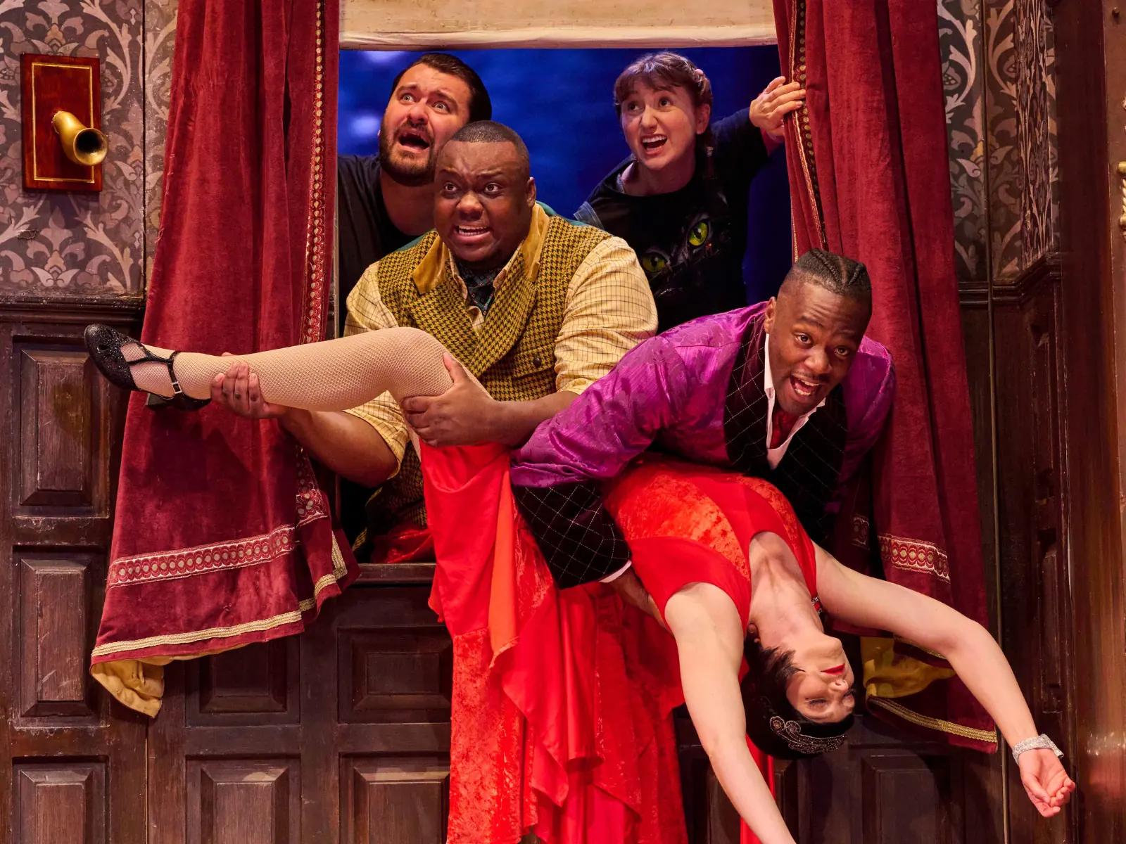 Florence is bundled out through a window in The Play That Goes Wrong, Duchess Theatre
