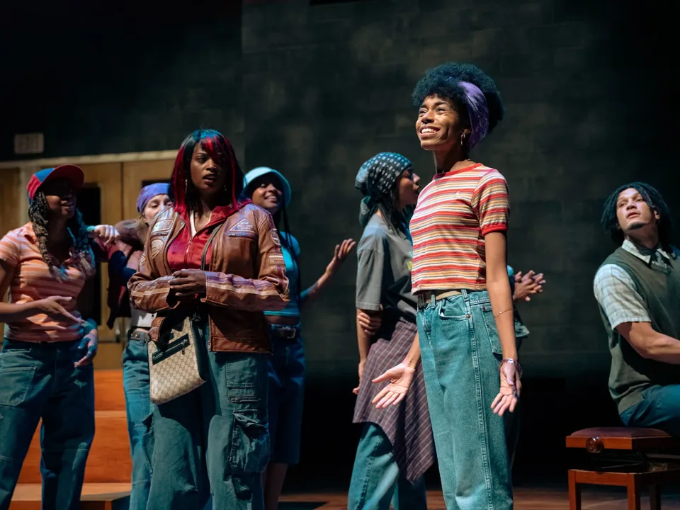 Young people in caps and denim sing together in The Story, Olivier Theatre