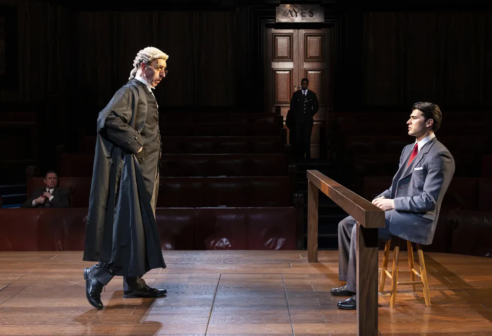 A wigged barrister approaches a seated young man: Witness for the Prosecution, County Hall